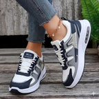 Navy and gray sneakers with white accents on a wooden floor.