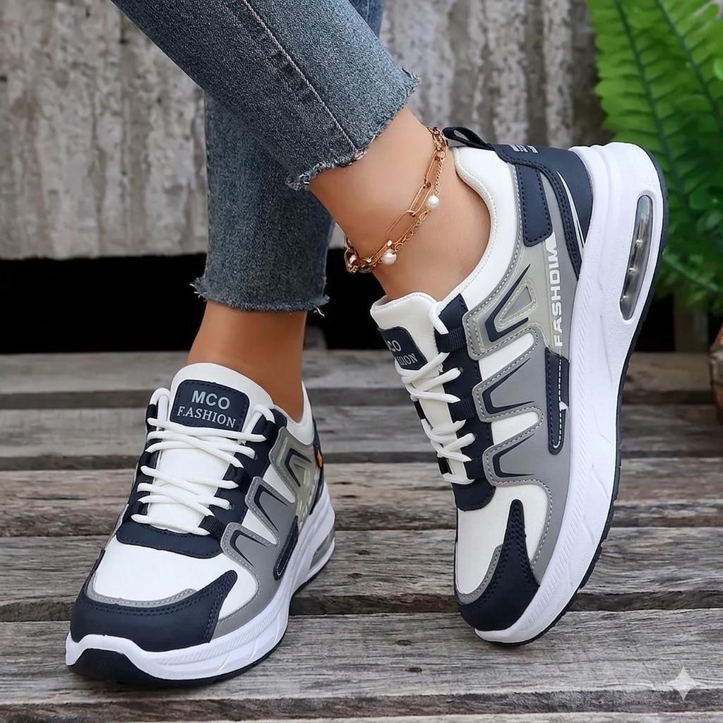 Navy and gray sneakers with white accents on a wooden floor.