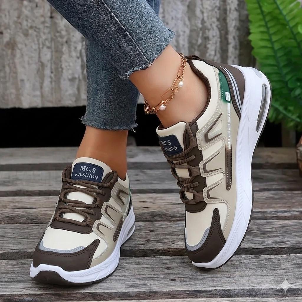 Pair of brown and beige sneakers on a wooden floor with a blurred background