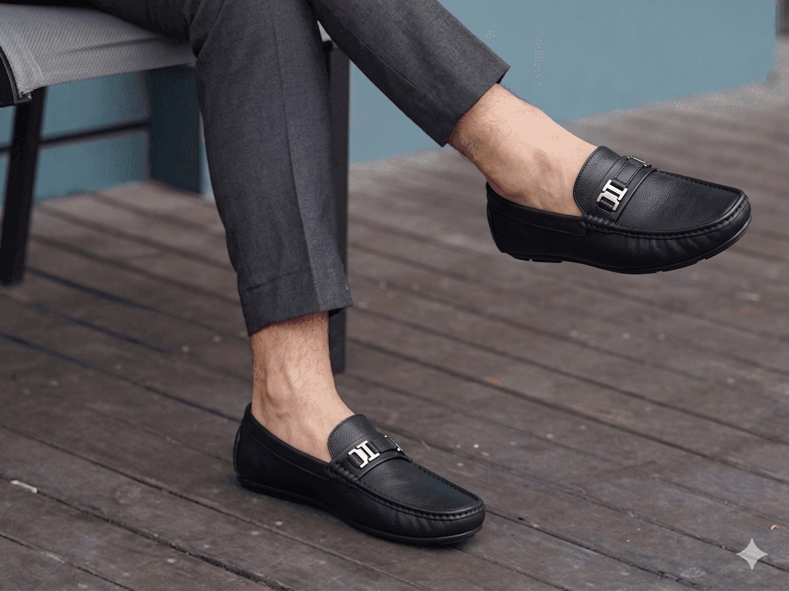 Person wearing black loafers on a wooden floor