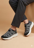 Gray sneakers worn with dark pants on a beige background