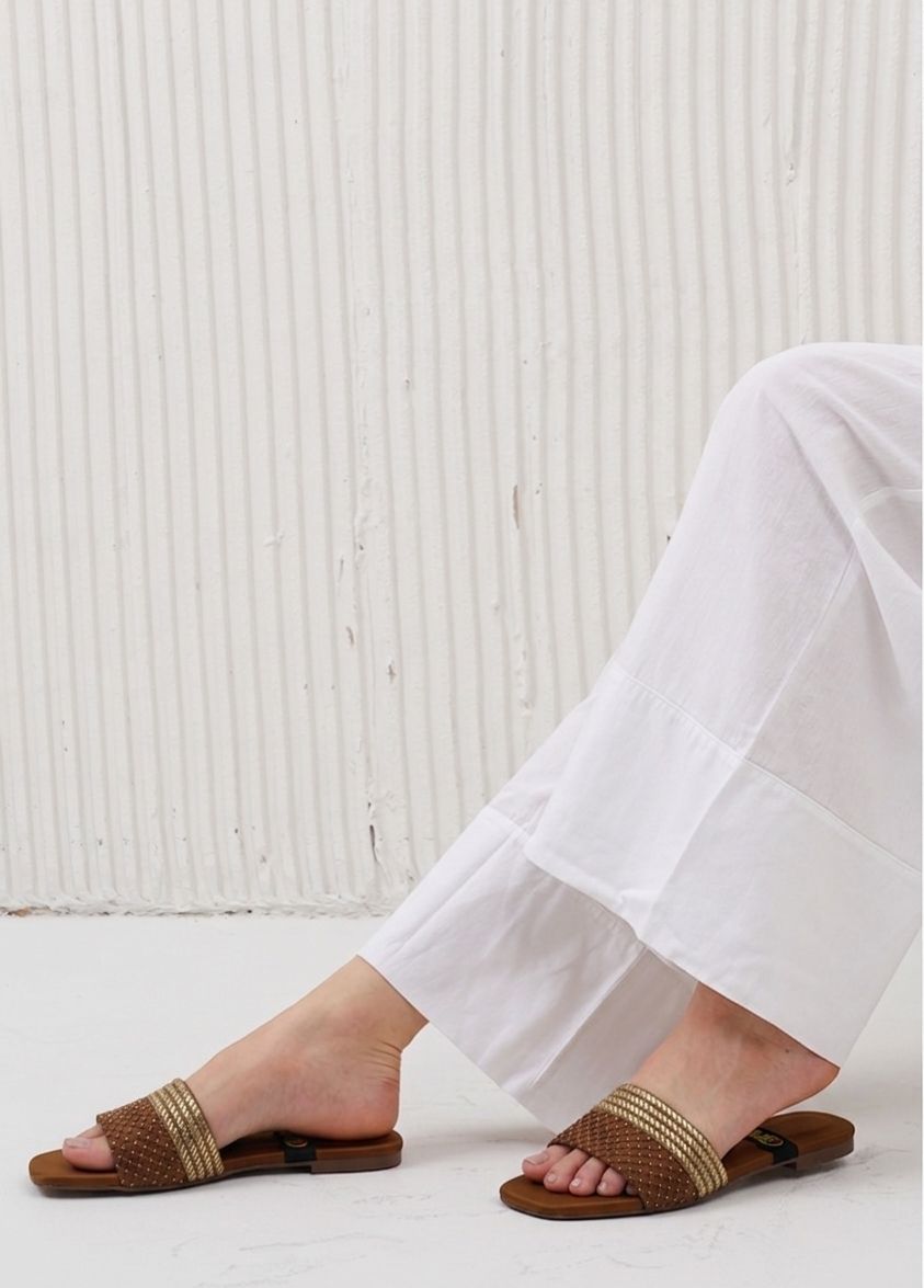 Clear PVC party flats featuring a shimmering rhinestone heart and secure ankle strap.