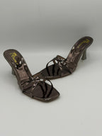 Pair of brown high-heeled sandals on a light gray background