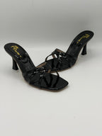 Black patent leather high-heeled shoes on a white background