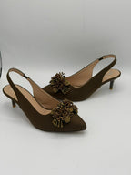 Brown high-heeled shoes with decorative elements on a white background
