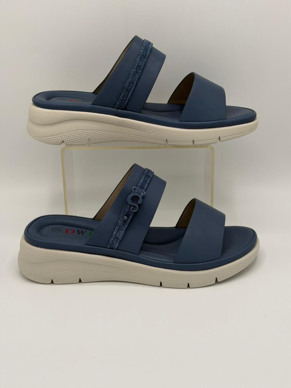 Pair of navy sandals with beige soles on a white background