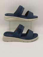 Pair of navy sandals with beige soles on a white background