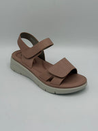Brown sandal with a white sole on a gray background