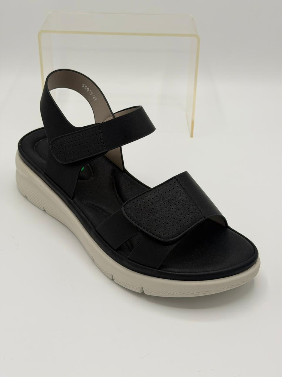 Black sandal with a white sole on a light gray background
