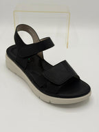 Black sandal with a white sole on a light gray background