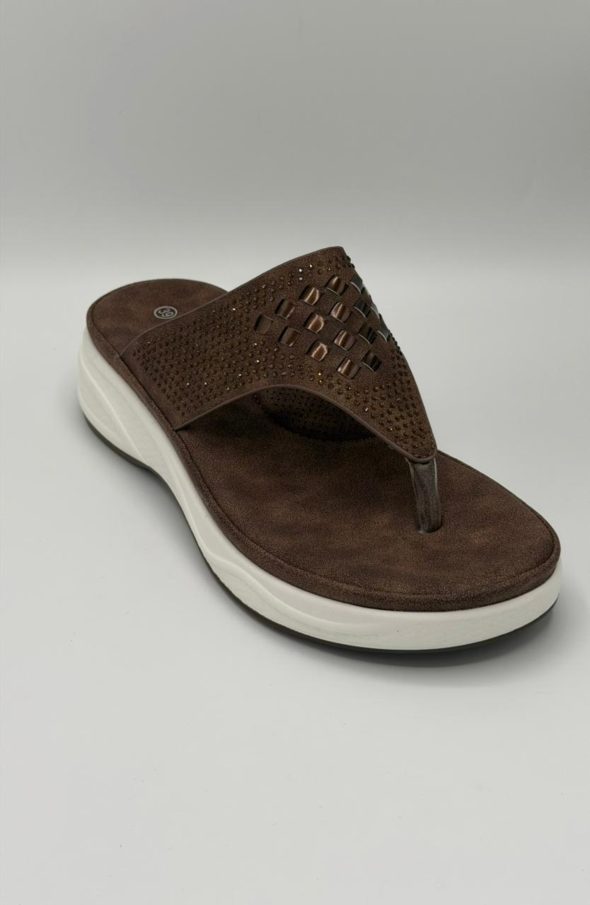 Brown sandal with a white sole on a gray background