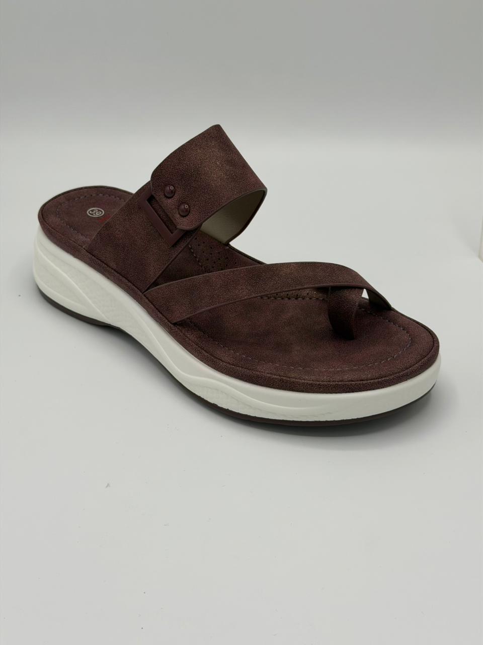 Brown sandal with white sole on a light gray background