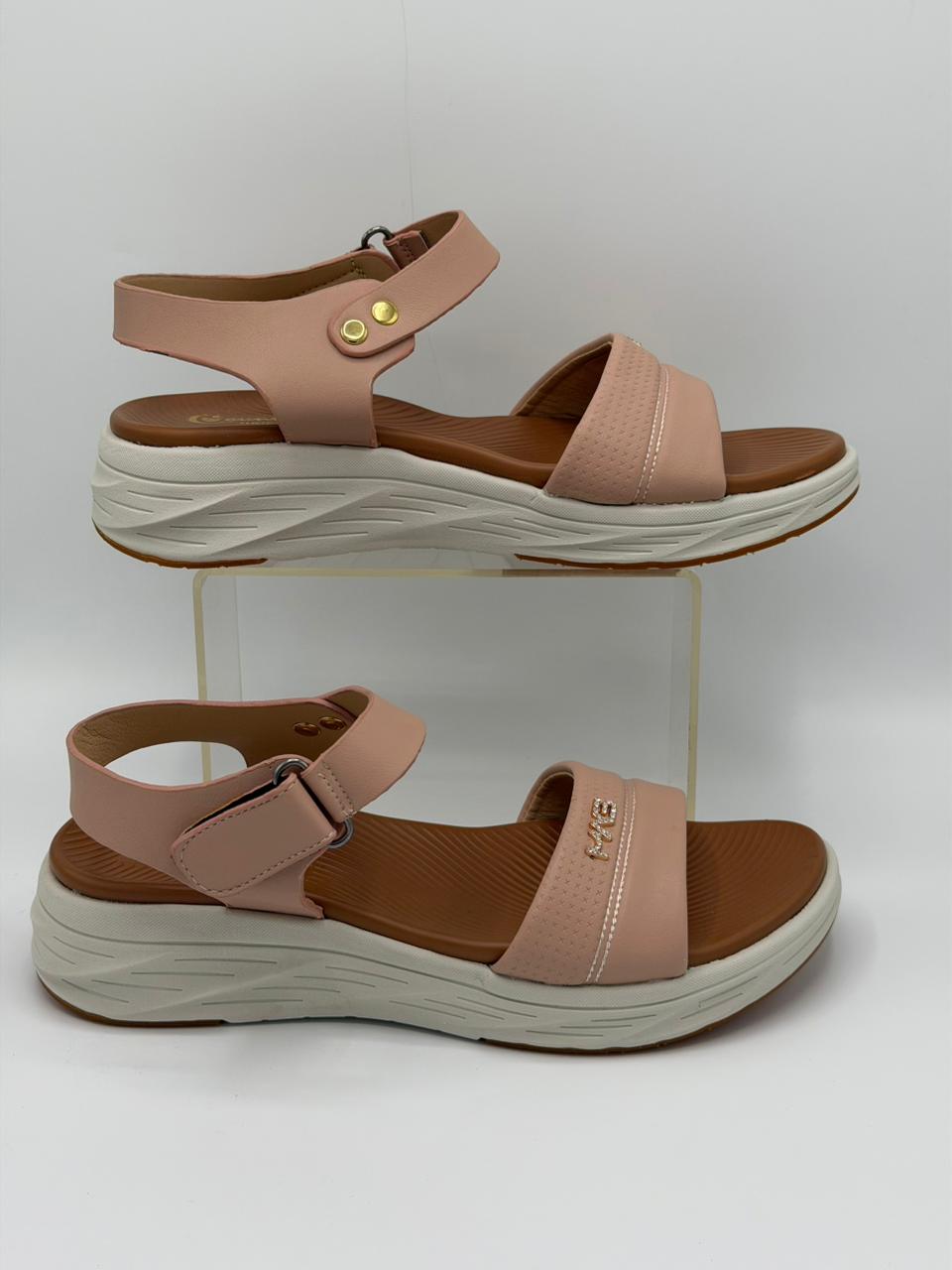 Pair of pink sandals with brown soles on a white background