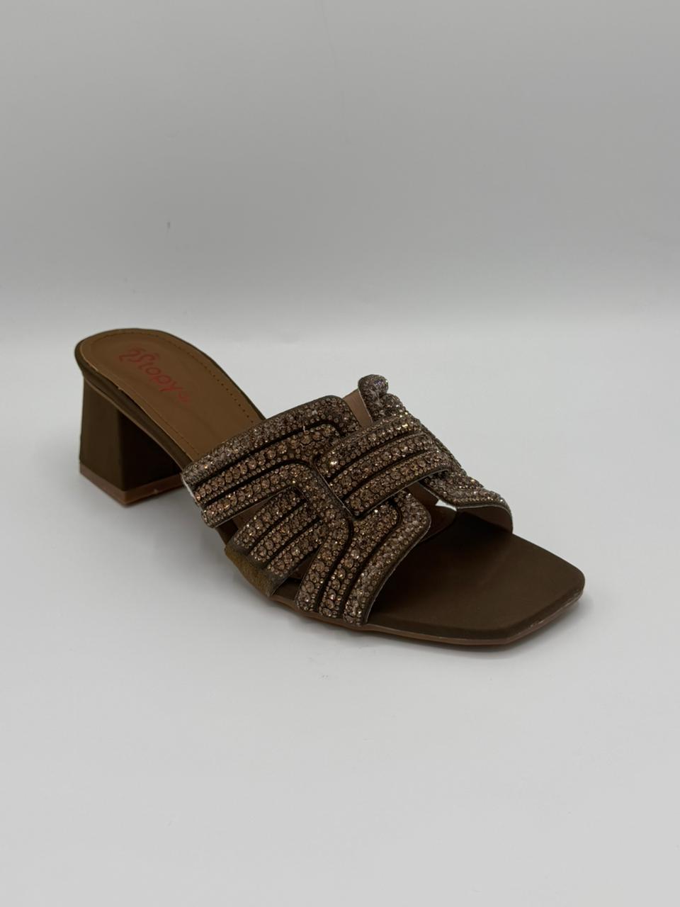Brown sandal with decorative straps on a gray background