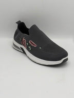 A dark gray slip-on sneaker with a textured mesh upper, featuring a pink and white floral design on the side, a white midsole, and a black outsole.