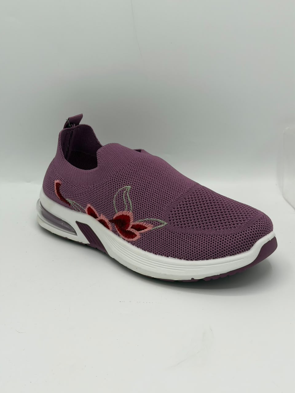 A single slip-on mesh sneaker in a muted purple color, featuring a white sole and red embroidered floral details on the side.