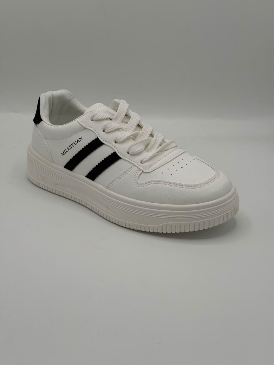A white low-top sneaker with three black stripes on the side, featuring a chunky white sole and the brand name 'MELISTEAN' printed in black on the side.