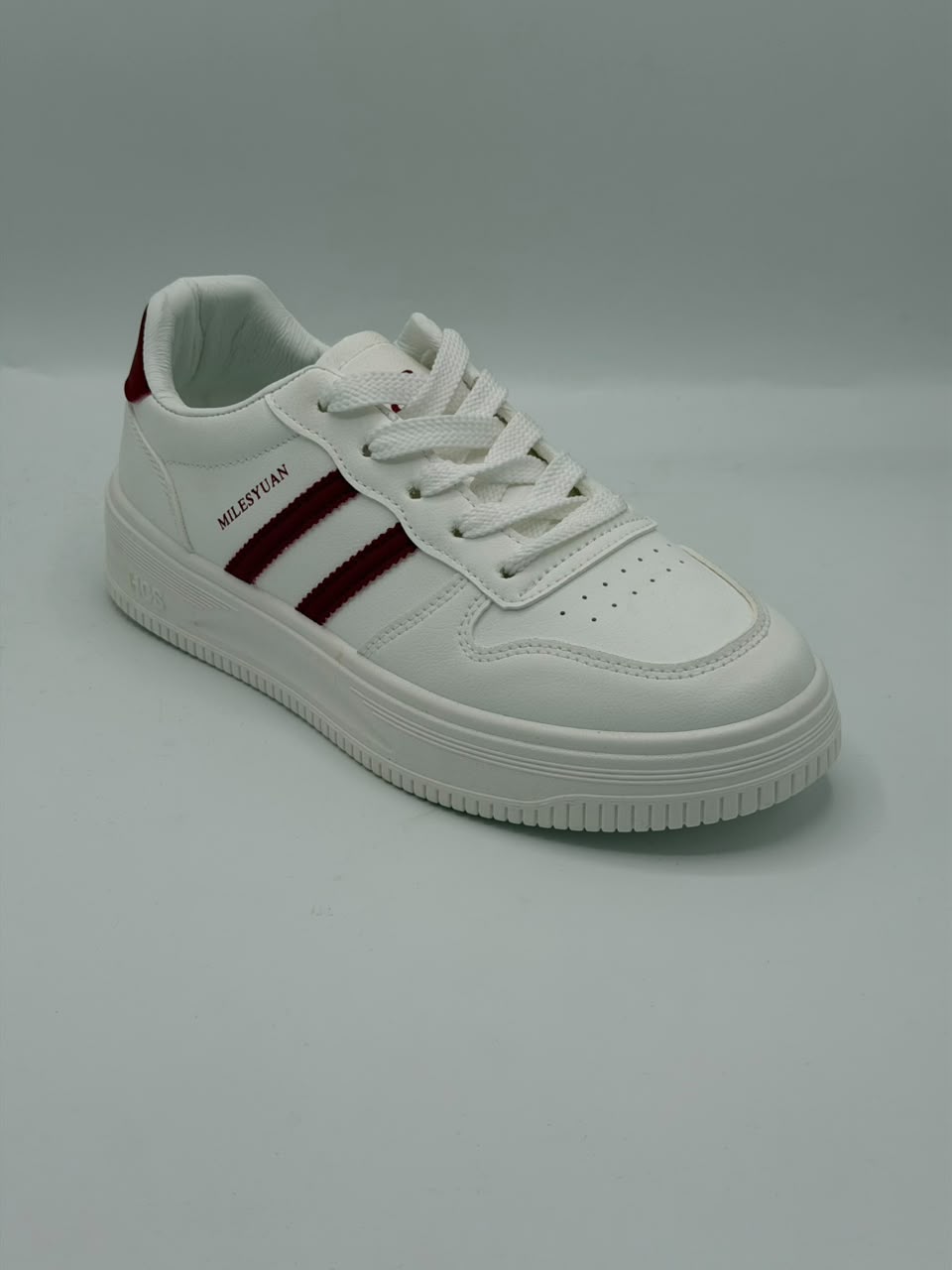A white low-top sneaker with three dark red stripes on the side, white laces, and the brand name 'MELTEDAN' printed in black on the side panel, set against a plain gray background.