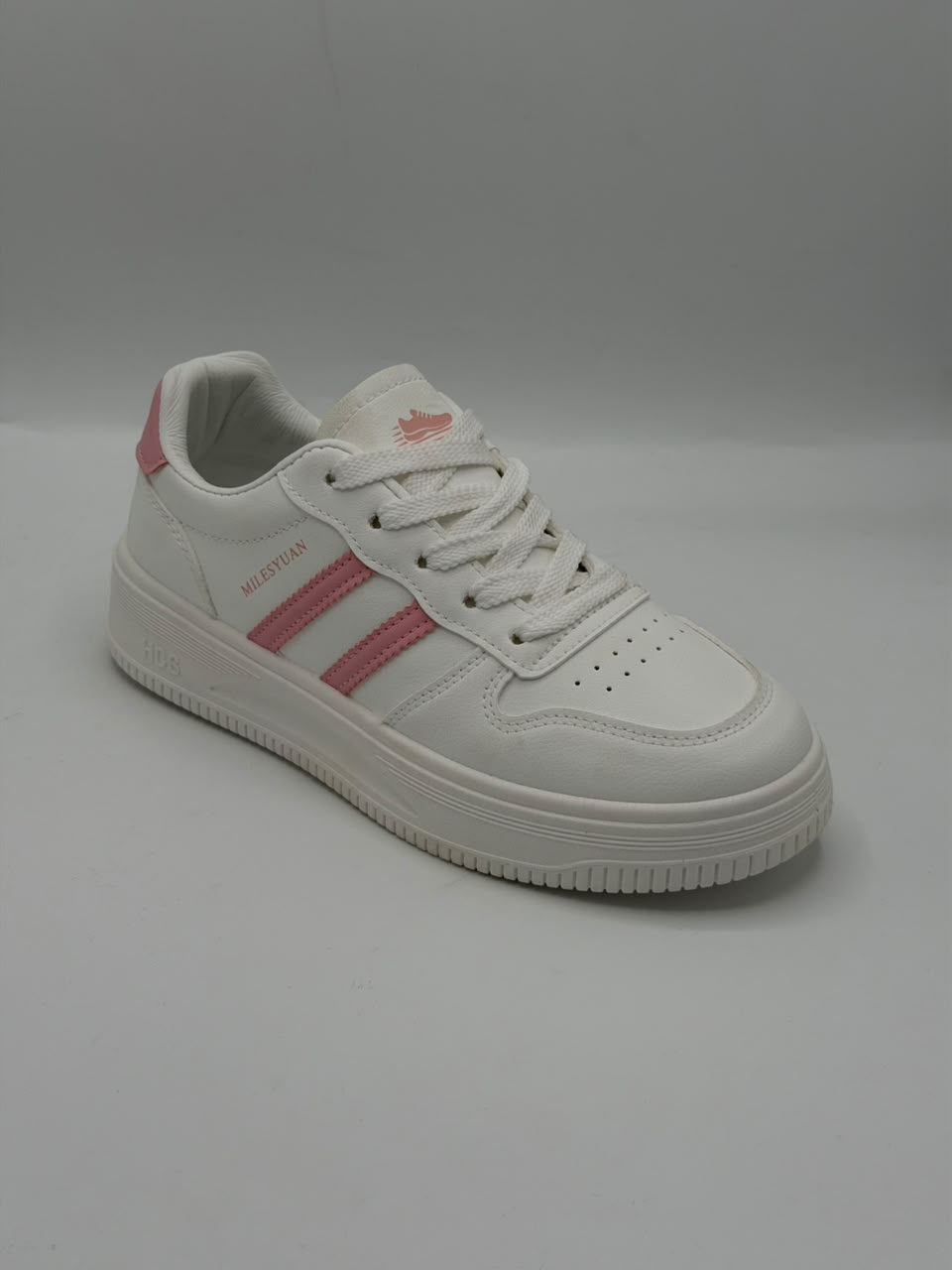 A white low-top sneaker with pink three-stripes and pink accents on the tongue and heel, photographed on a light gray background.