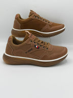 A pair of X-ONE brand brown low-top sneakers with a white midsole stripe, shown against a light gray background.