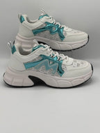 A pair of chunky white sneakers with metallic teal accents and a subtle geometric pattern, displayed on a neutral gray background.