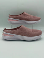 A pair of women's slip-on wedge sneakers in dusty rose pink with textured knit uppers, white soles, and a translucent pink heel accent, displayed on a light gray background with one shoe on a clear stand.