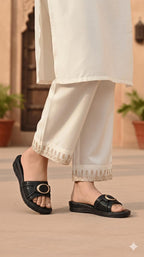 Person wearing black sandals with a beige background