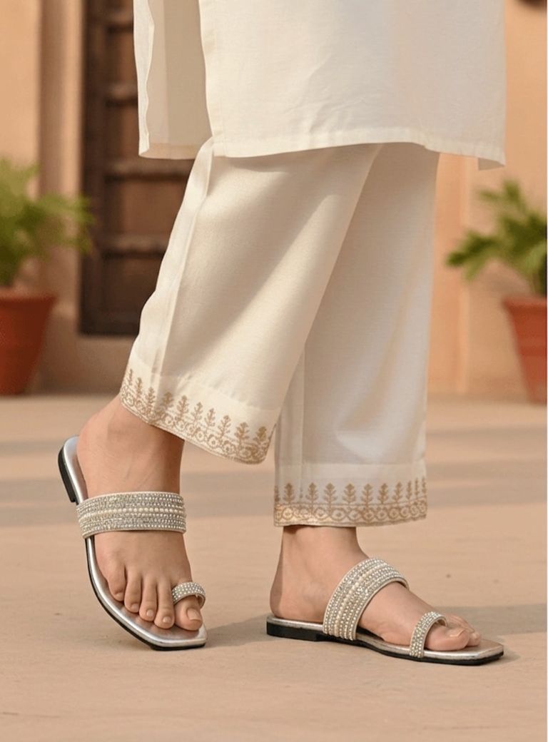 Person wearing silver sandals with a blurred background