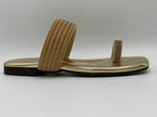 Gold sandals with textured straps on a white background