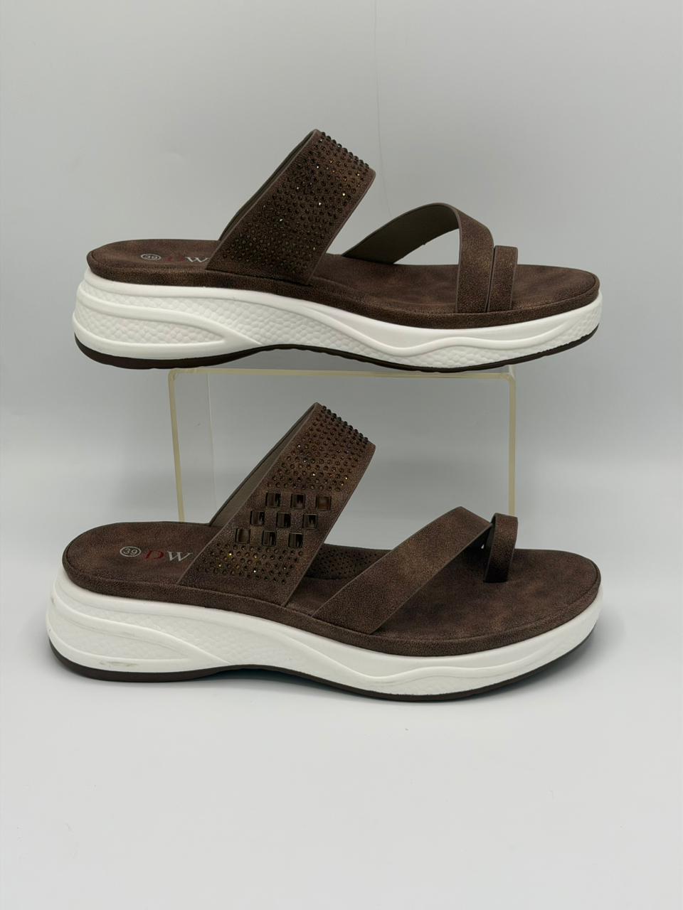 Brown sandals with white soles on a gray background