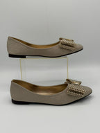 Pair of glittery flats with decorative bow on a white background