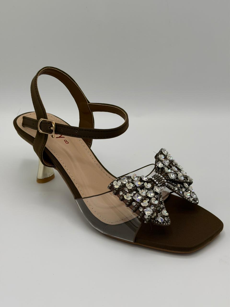 Brown sandal with a decorative bow on a gray background