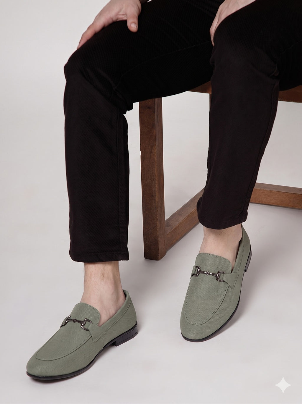 Person wearing black sandals with 'ACTIVE' branding, sitting on a wooden stool.