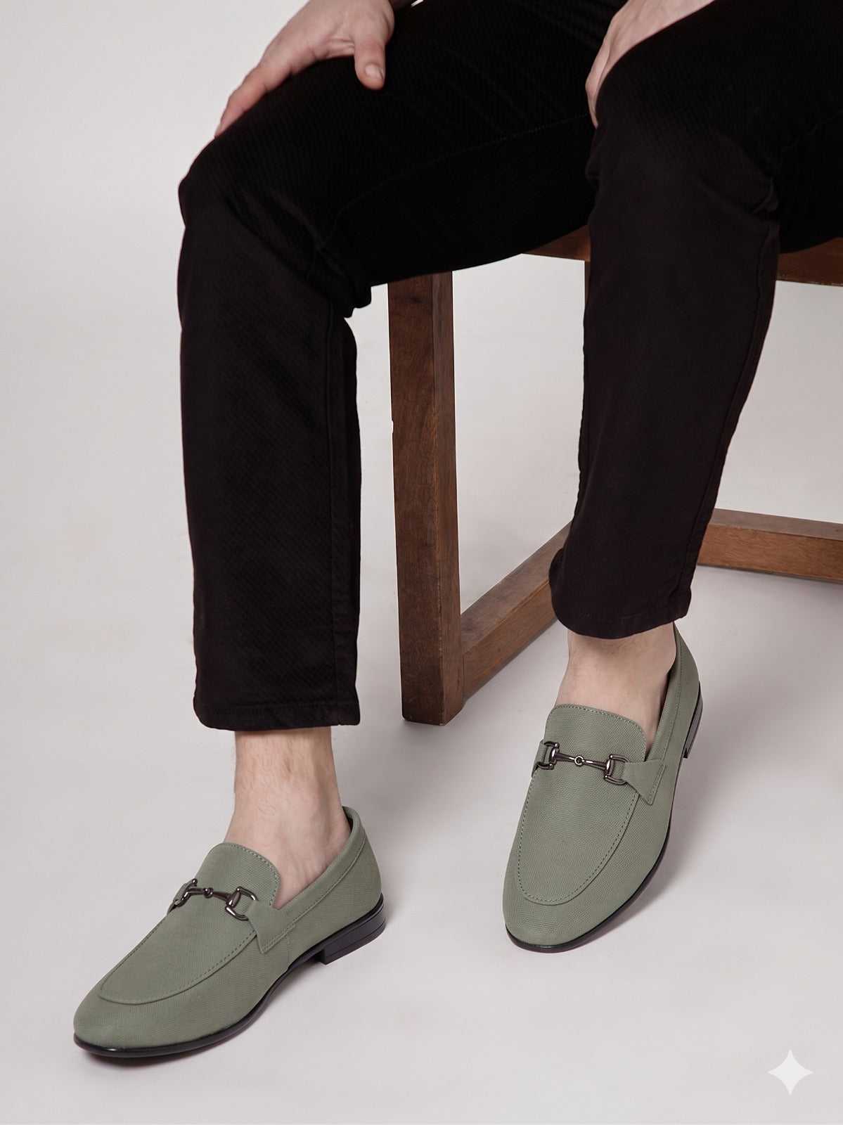 Person wearing black sandals with 'ACTIVE' branding, sitting on a wooden stool.