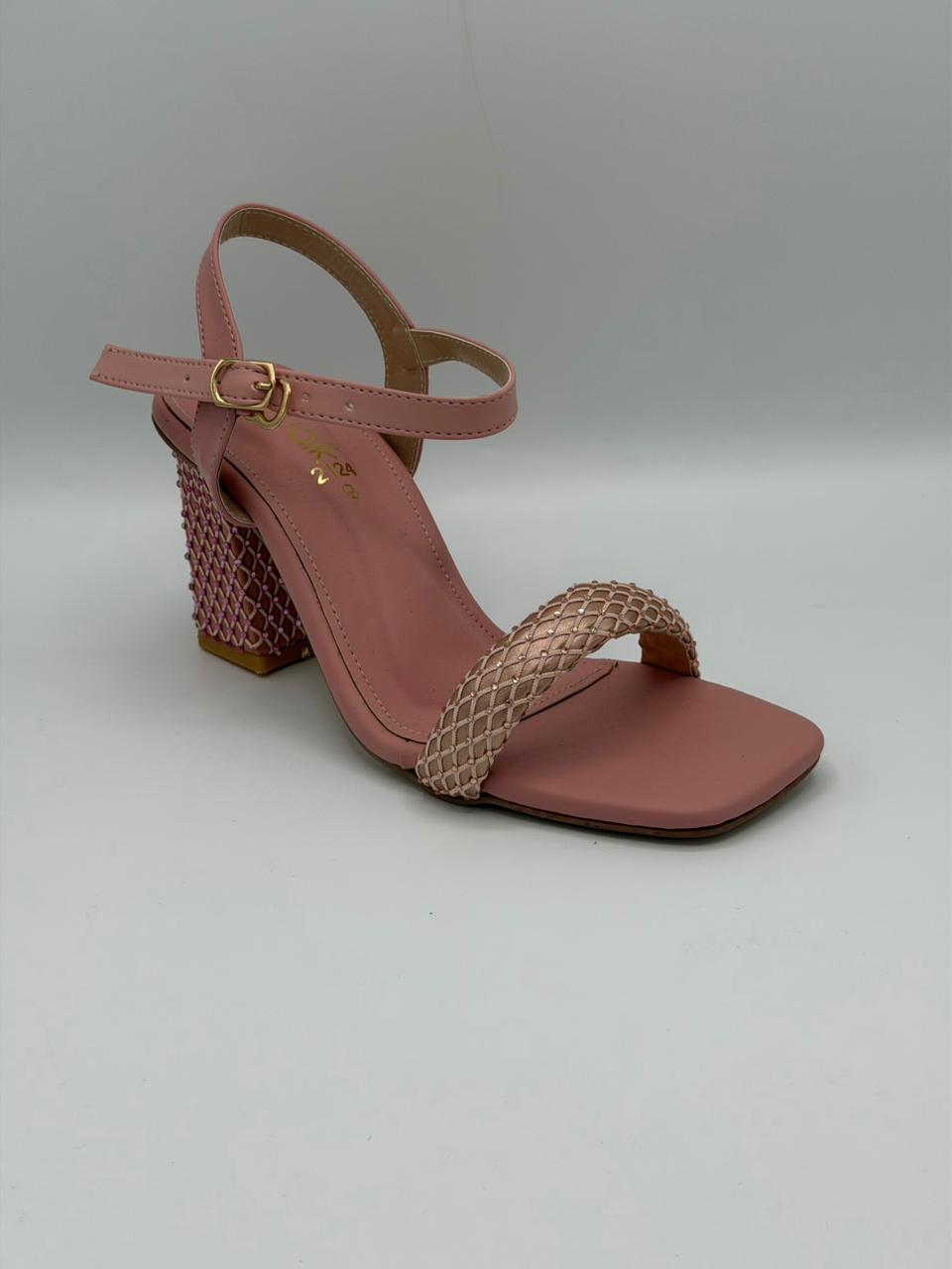 Pink sandal with woven heel on a light gray background