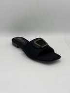 Black sandal with a square buckle on a light gray background