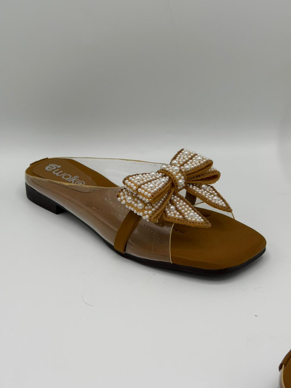 Brown sandal with a decorative bow on a white background