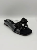 Black sandal with a decorative bow on a light gray background