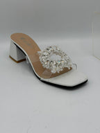 White sandal with clear gemstone embellishments on a white background