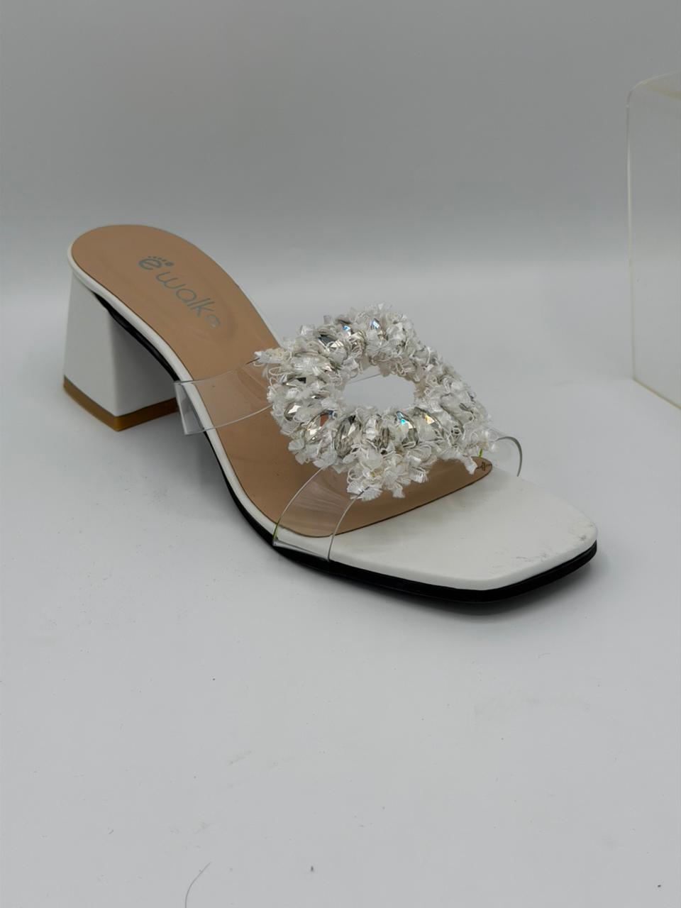 White sandal with clear gemstone embellishments on a white background