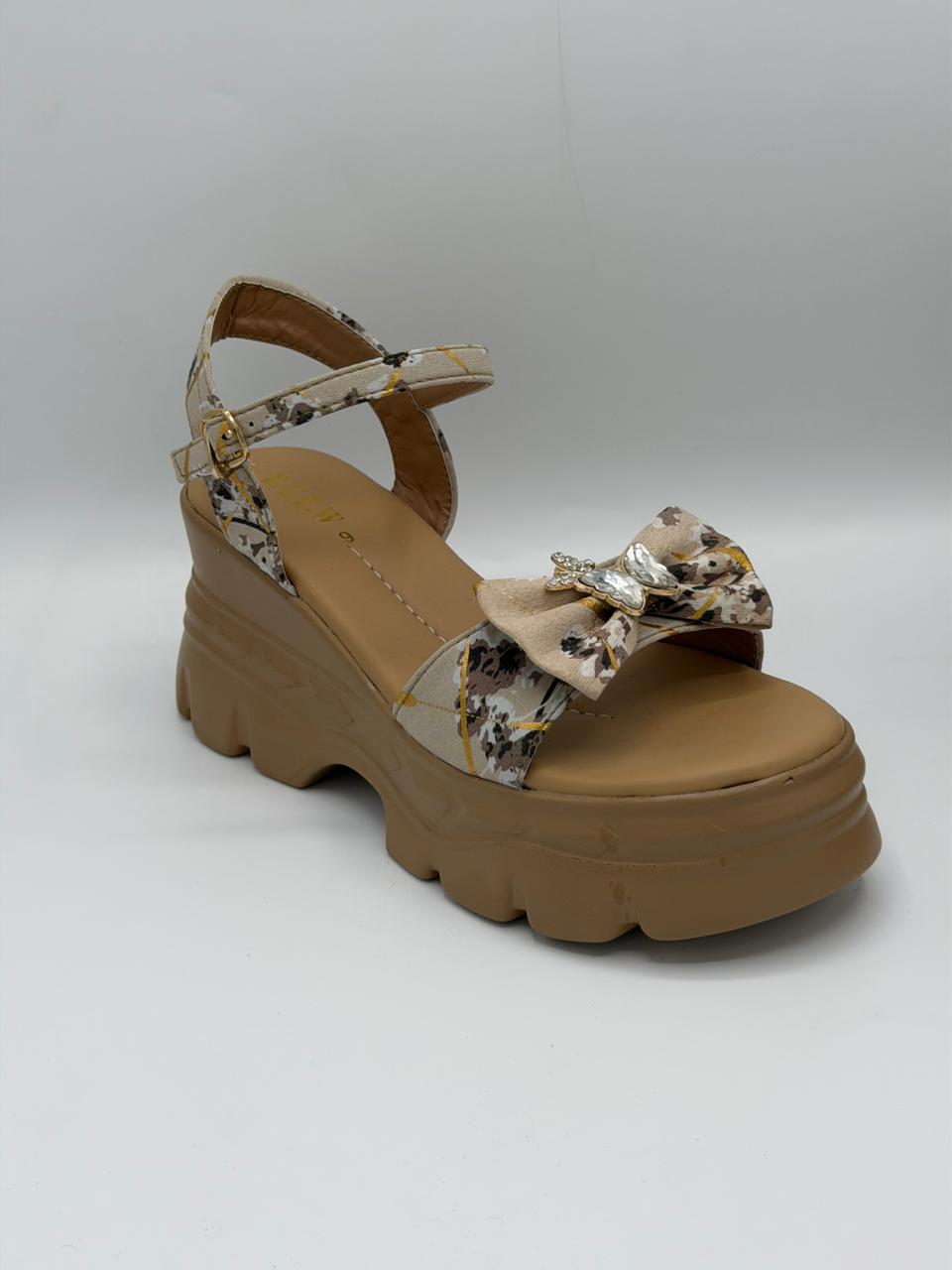 Tan sandal with floral straps on a white background