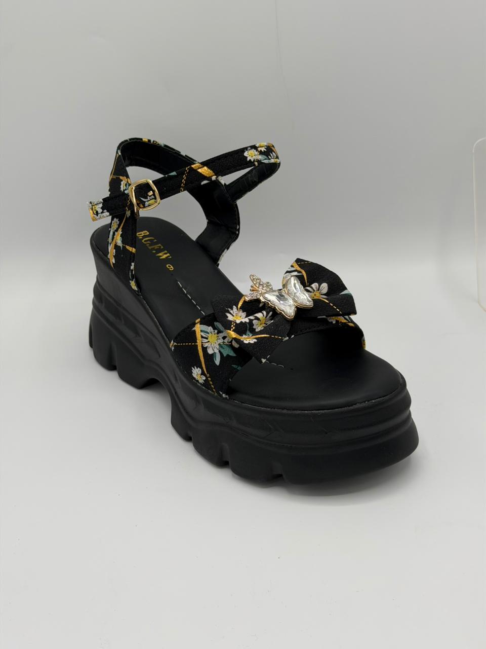 Black sandal with floral embroidery on a white background