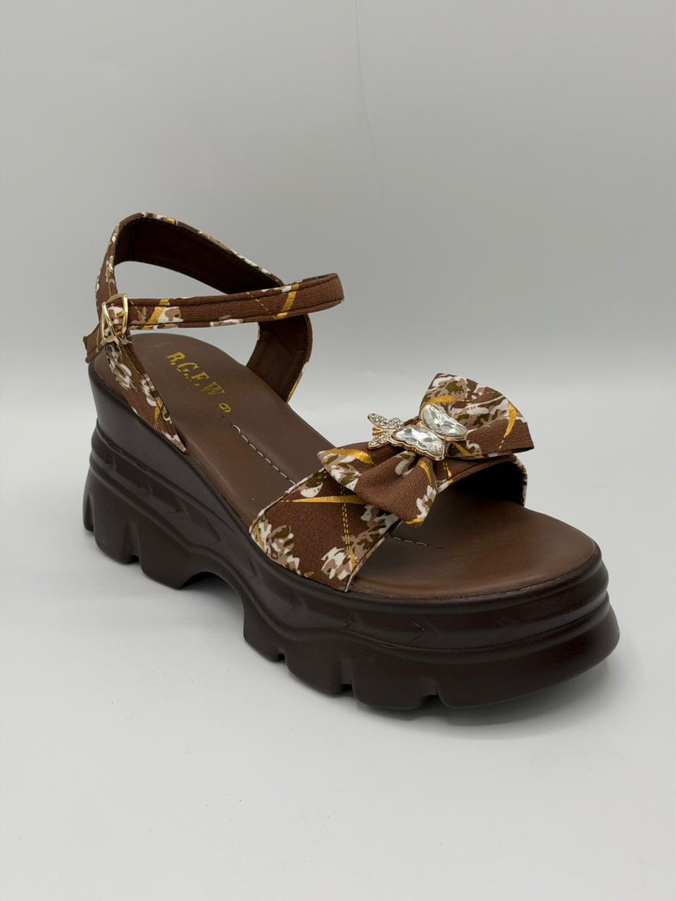 Brown sandal with floral straps on a gray background
