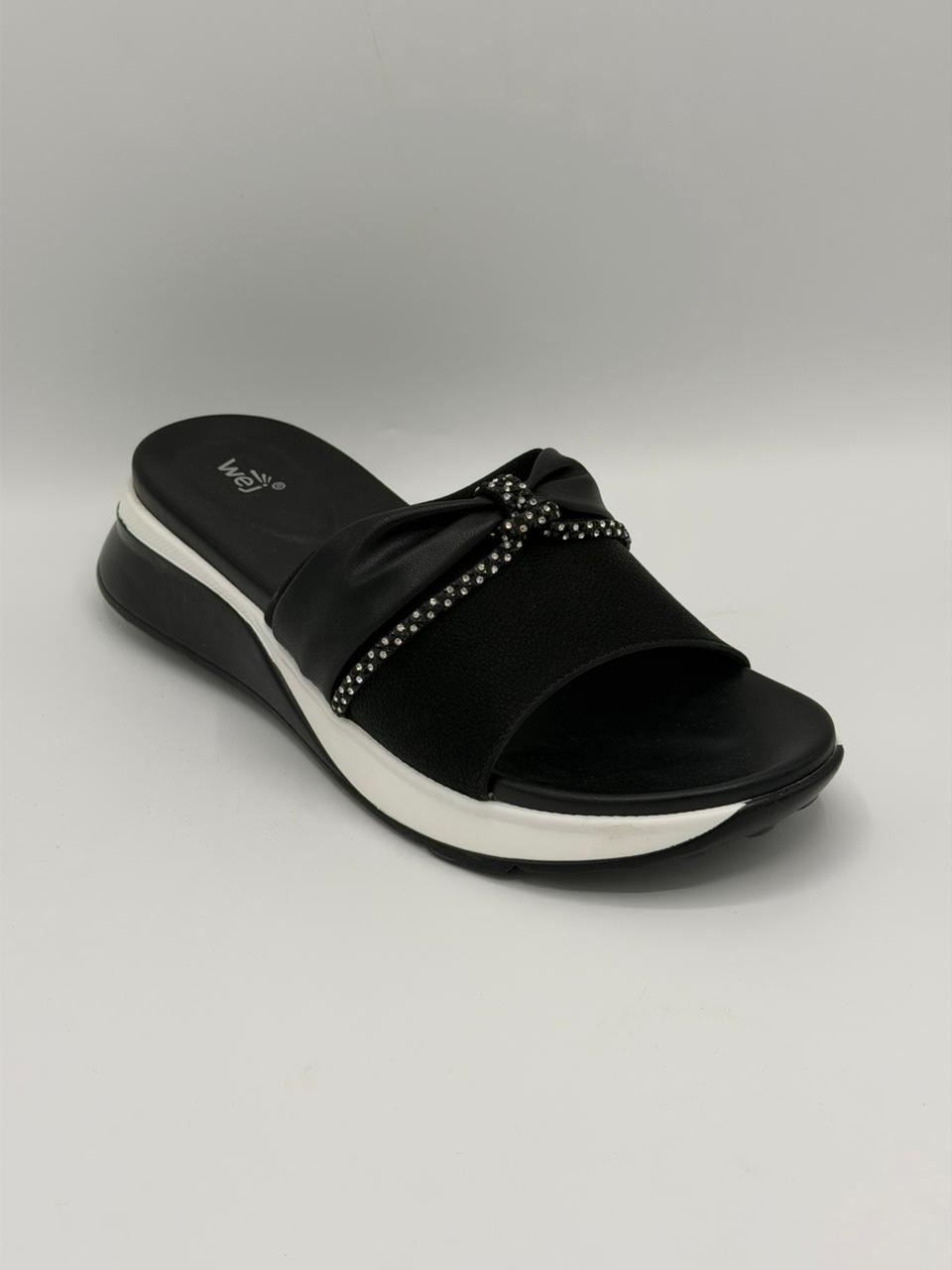 Black sandal with white sole on a gray background