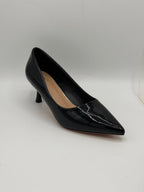 Black high-heeled shoe on a light gray background