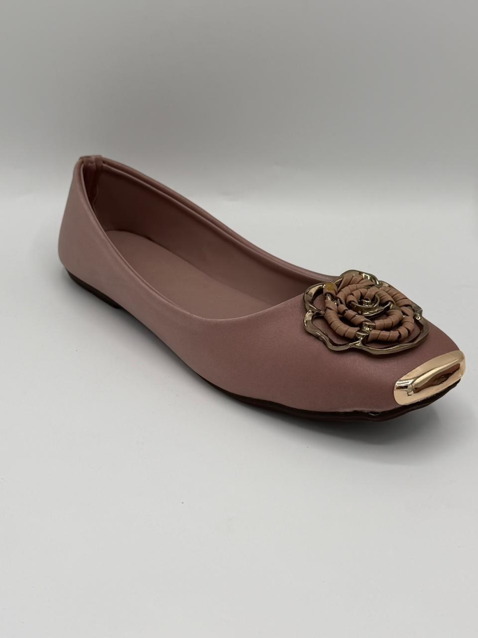 Brown flat shoe with a decorative flower on a light gray background