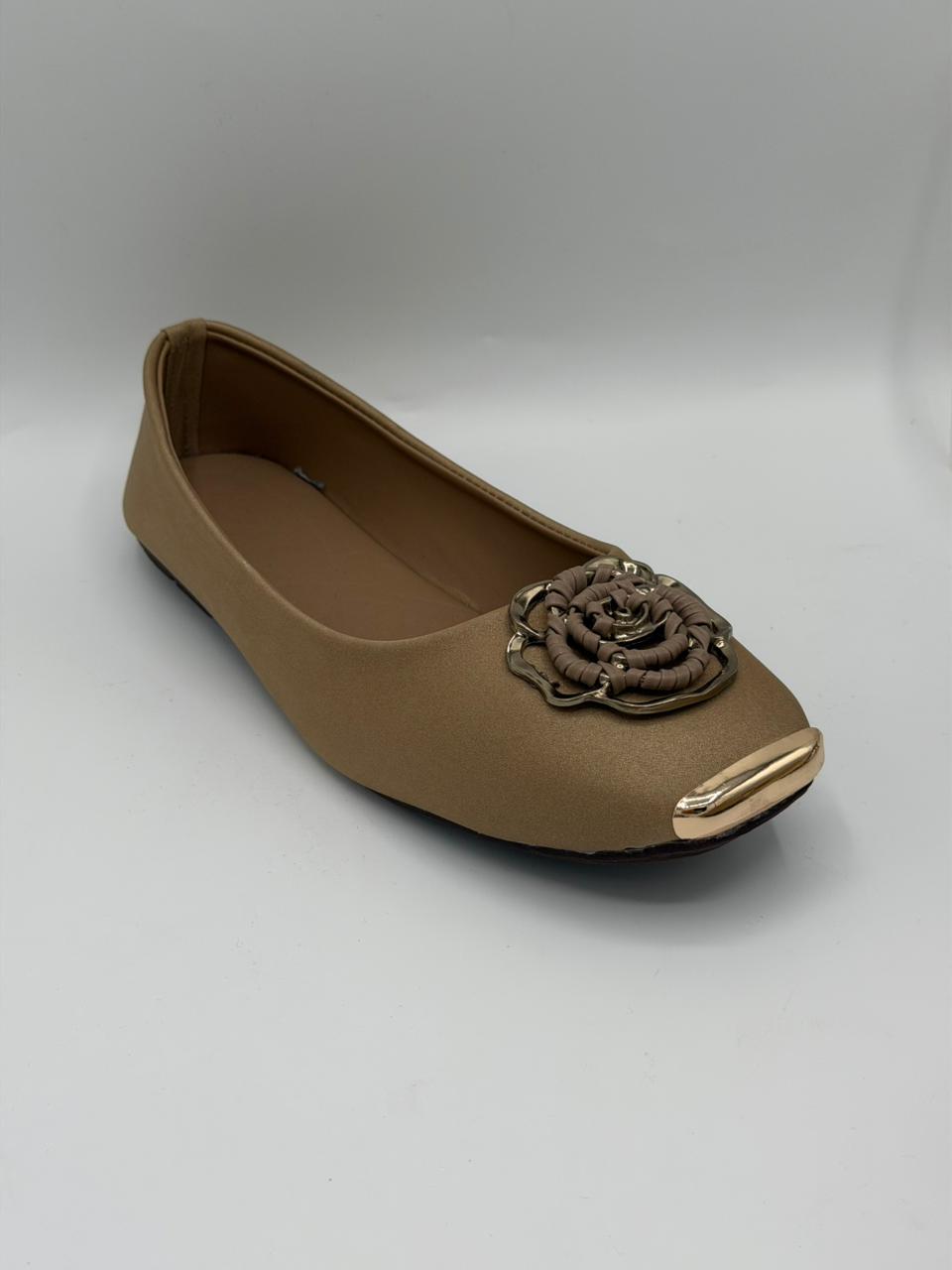Brown flat shoe with a decorative flower on a gray background