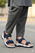 Person wearing navy sandals with white soles on a blurred street of the north face company background